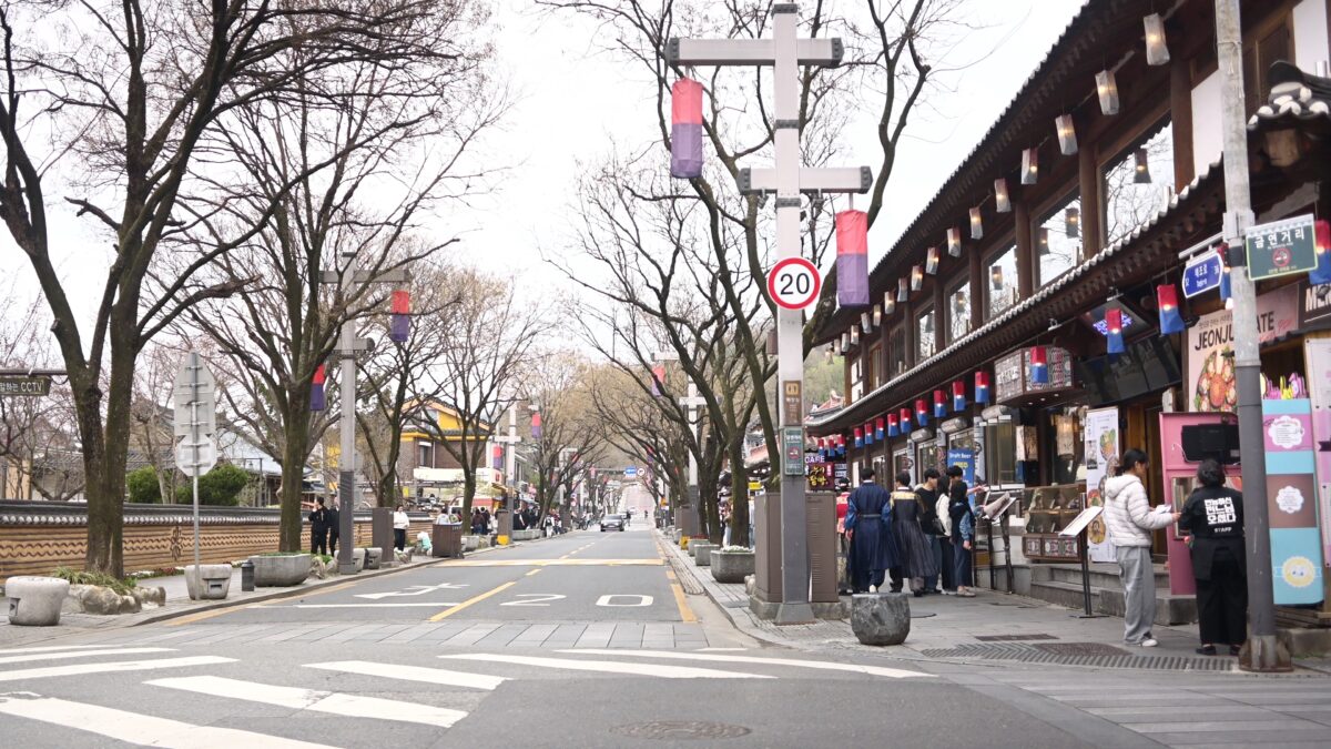 Street scene in Jeonju Hanok Village with traditional Korean houses and visitors walking along the alley